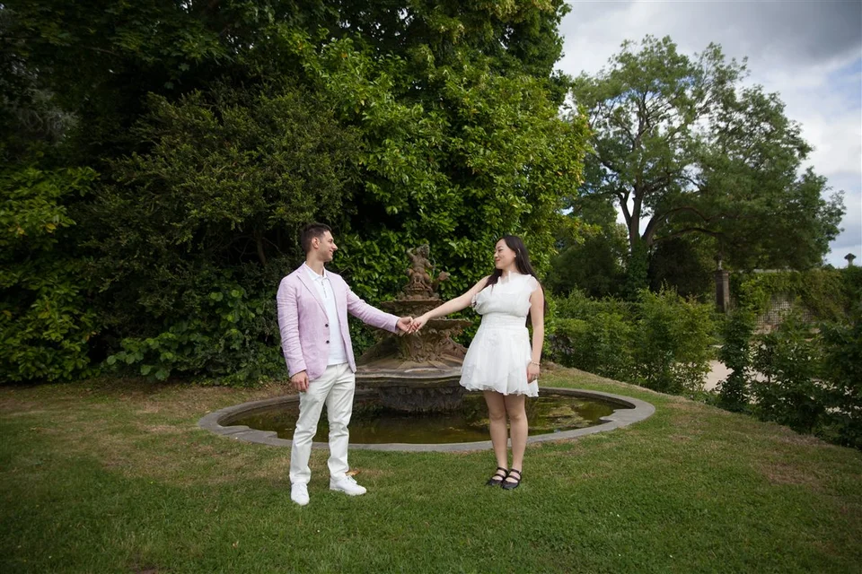 Alex and Yashi holding hands in a garden