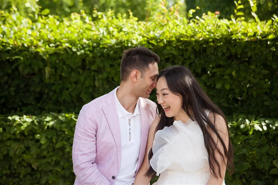 Alex and Yashi standing close together in a garden